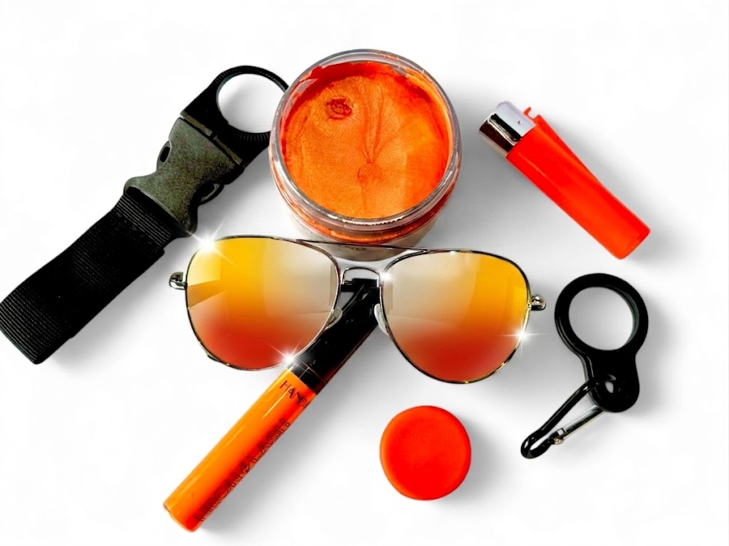 Holland Feestpakket met oranje haarwax, neon mascara, oranje spiegelende pilotenbril, stash aansteker, festivaldop, flesclips en haakje – feestelijke oranje festivalaccessoires op een witte achtergrond.
