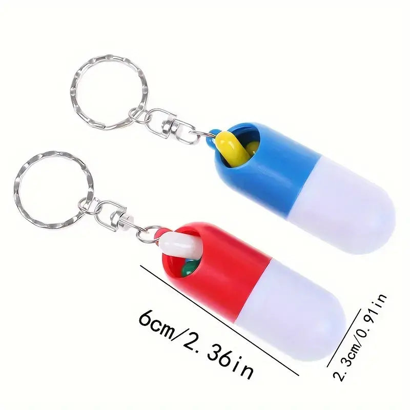 Capsulevormig pillendoosje met sleutelhanger in rood en blauw, met eenvoudig draai-mechanisme om te openen en te sluiten