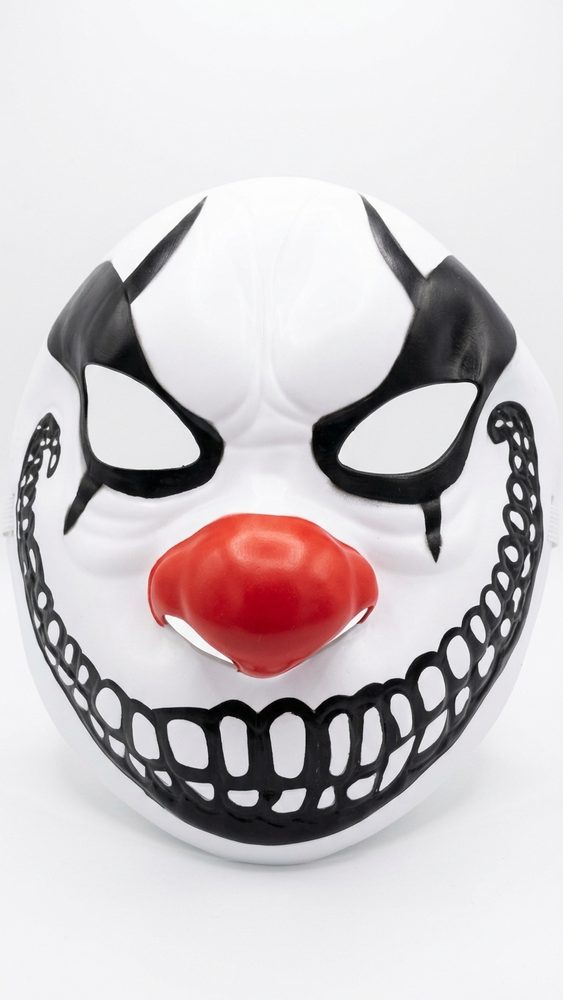 Wit horror clown masker met zwarte ogen, rode neus en brede zwarte grijns met tanden