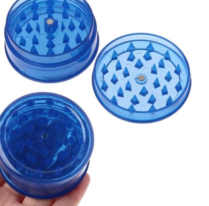 Compacte blauwe kruiden grinder van stevig plastic, handig voor het fijnmalen van kruiden en specerijen.