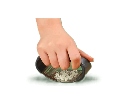 Hand die de Truffel Crusher gebruikt om truffels of knoflook te raspen, perfect voor culinaire toepassingen en efficiënt koken.